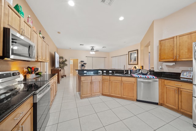 kitchen with light tile patterned floors, stainless steel appliances, kitchen peninsula, and sink