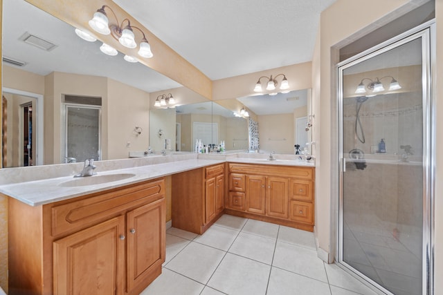 bathroom featuring vanity, a shower with shower door, and tile patterned floors