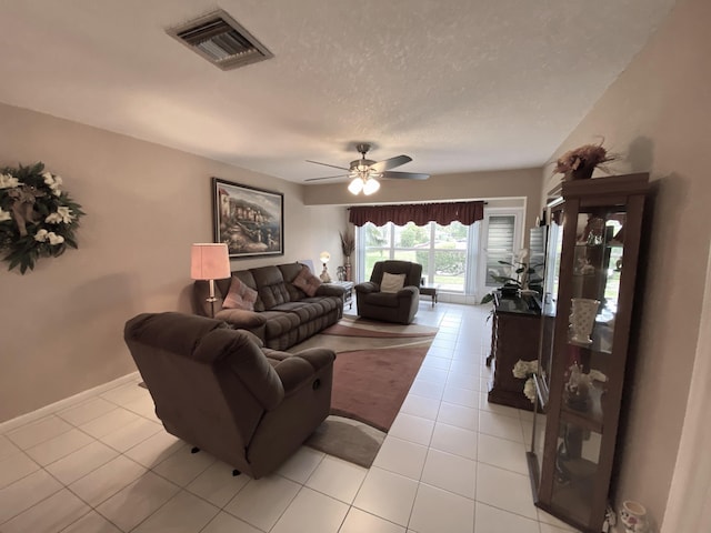 tiled living room with a textured ceiling and ceiling fan