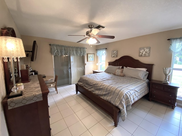 bedroom with a textured ceiling, ceiling fan, and light tile patterned floors