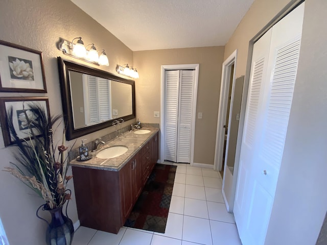 bathroom with tile patterned flooring, a textured ceiling, and vanity