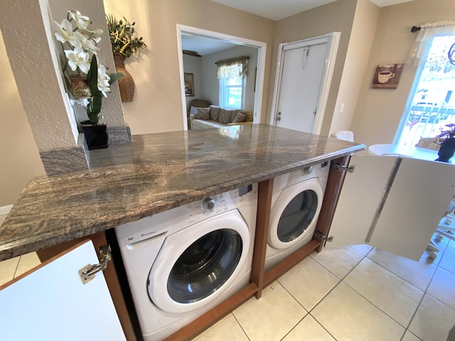 laundry area with washing machine and dryer and light tile patterned floors