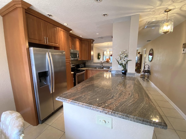 kitchen with pendant lighting, stainless steel appliances, light tile patterned floors, kitchen peninsula, and sink