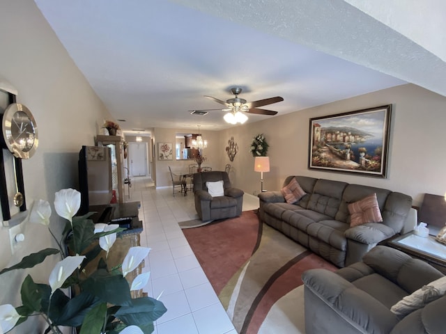 living room with ceiling fan with notable chandelier and light tile patterned floors