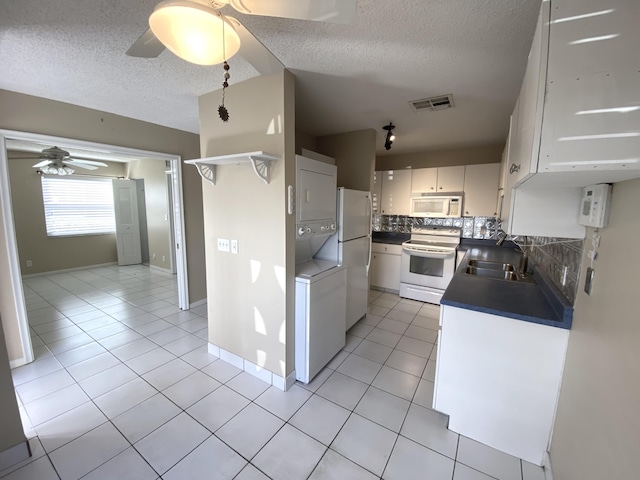 kitchen with white cabinets, decorative backsplash, white appliances, and a textured ceiling