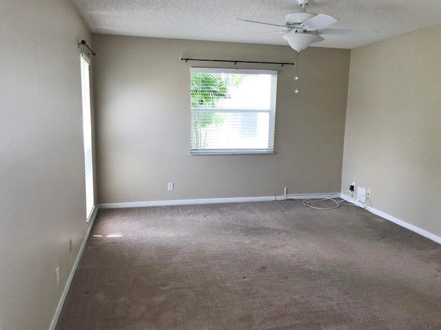 carpeted spare room with a textured ceiling, ceiling fan, and a healthy amount of sunlight