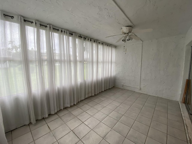 unfurnished sunroom with ceiling fan