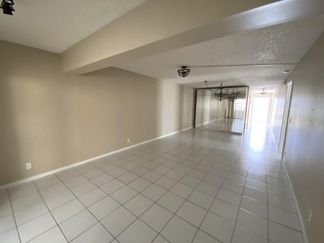 spare room with light tile patterned floors and a textured ceiling