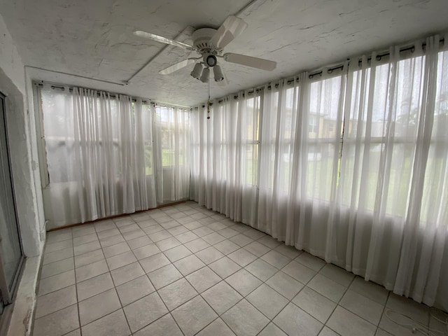 unfurnished sunroom with ceiling fan