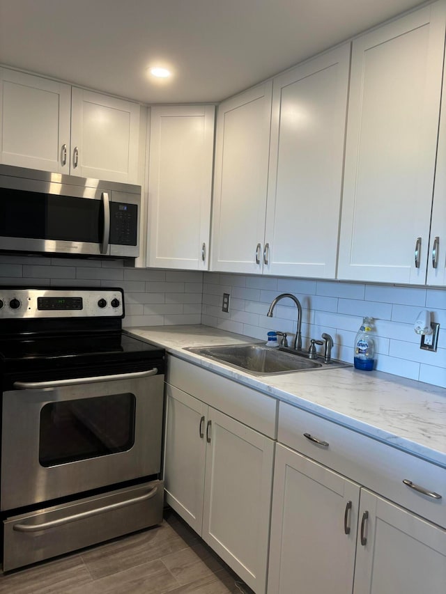 kitchen featuring white cabinetry, hardwood / wood-style floors, stainless steel appliances, and sink