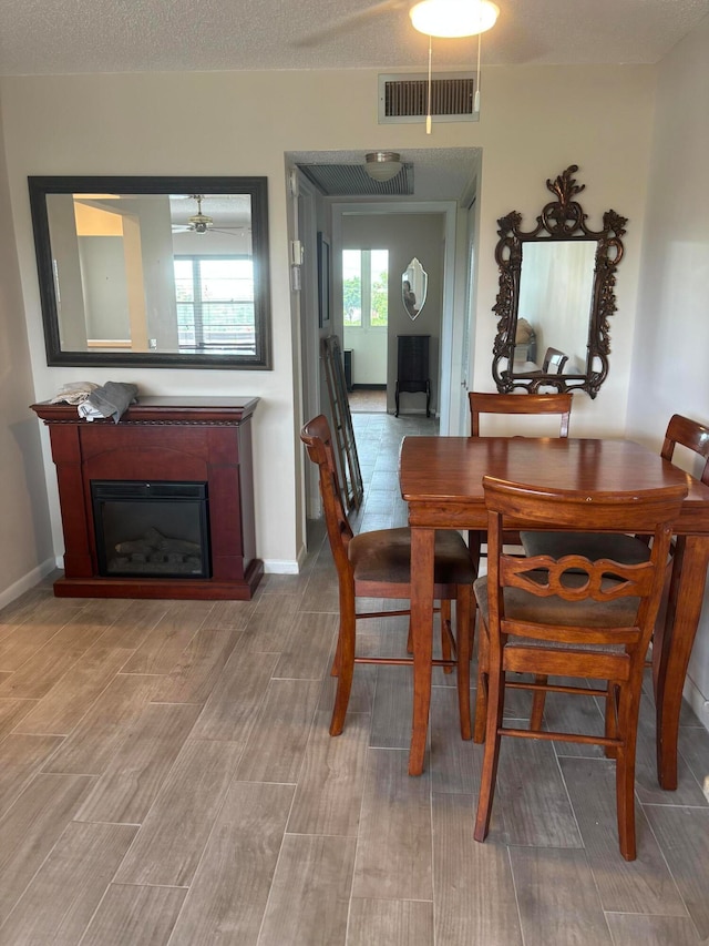 dining area featuring a textured ceiling and wood-type flooring