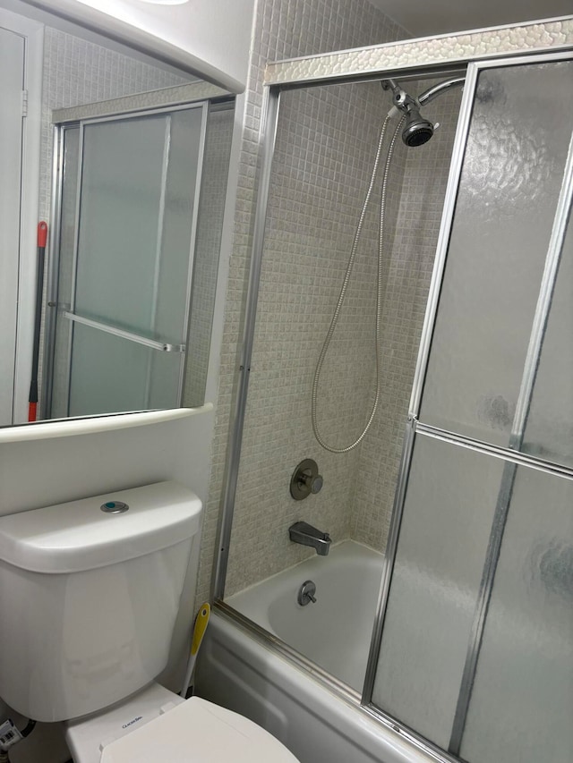 bathroom with shower / bath combination with glass door and toilet