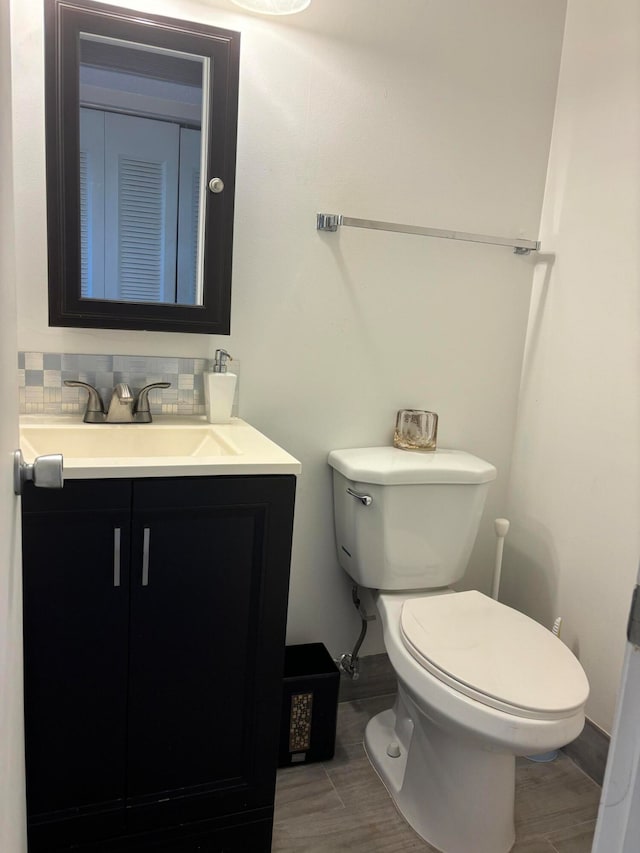 bathroom with toilet, tasteful backsplash, and vanity