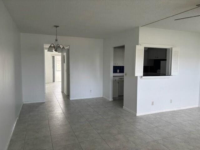 unfurnished room with a notable chandelier