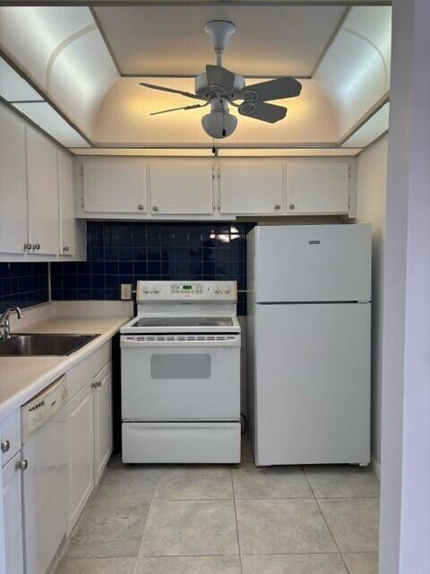 kitchen with sink, white appliances, ceiling fan, white cabinetry, and tasteful backsplash