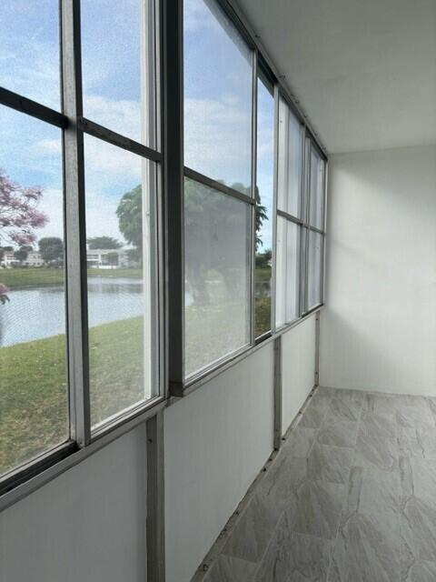 unfurnished sunroom featuring a water view