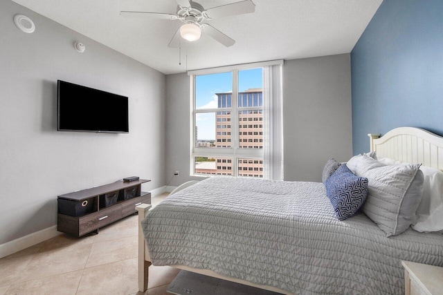 tiled bedroom featuring ceiling fan