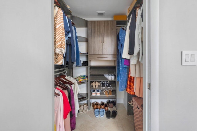 walk in closet with light tile patterned floors