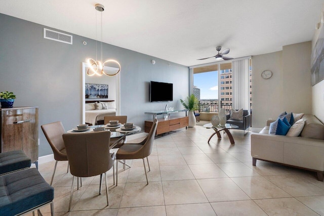 dining space with ceiling fan, a wall of windows, and light tile patterned floors