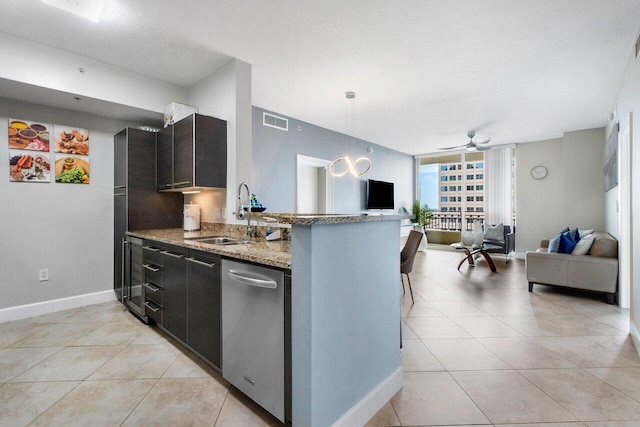 kitchen with light stone countertops, kitchen peninsula, ceiling fan, sink, and pendant lighting