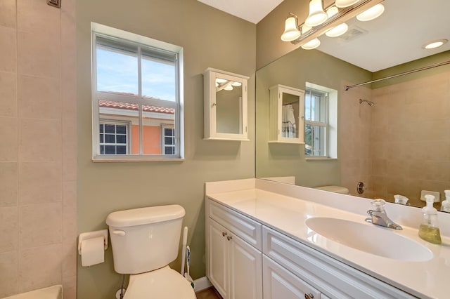 bathroom with vanity, toilet, and a tile shower