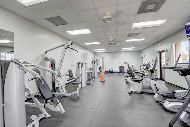 gym with a paneled ceiling and ceiling fan