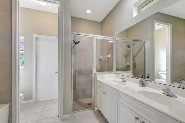 bathroom with a shower with shower door, tile patterned flooring, toilet, and vanity