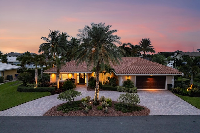 view of front facade featuring a garage and a lawn