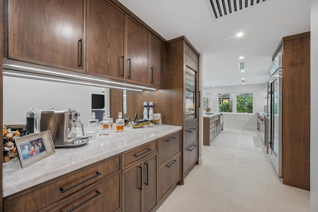 kitchen featuring light tile patterned floors and light stone countertops