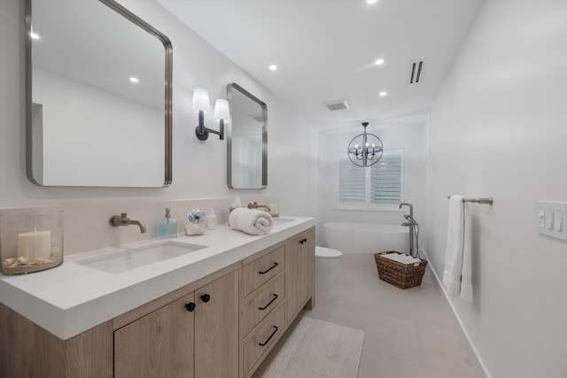 bathroom with tile patterned flooring, an inviting chandelier, toilet, a bath, and vanity