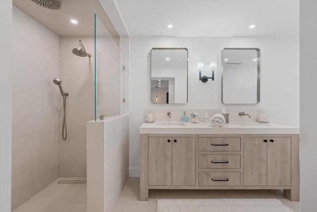 bathroom with vanity, tiled shower, and tile patterned flooring