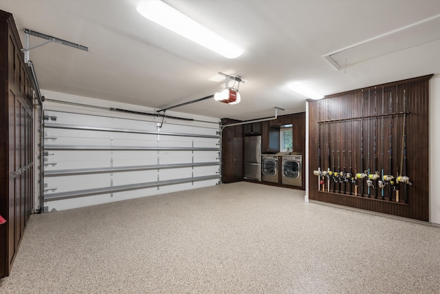 garage with a garage door opener, washing machine and clothes dryer, and stainless steel refrigerator