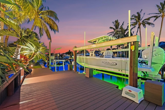 deck at dusk featuring a dock and a water view