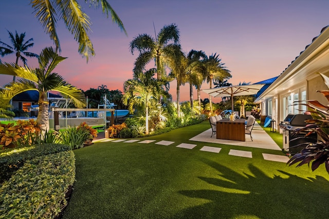 yard at dusk featuring a patio