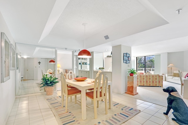 dining area featuring light tile patterned floors and a textured ceiling