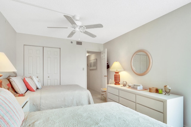 bedroom featuring ceiling fan, a textured ceiling, and a closet