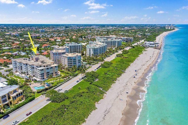 birds eye view of property with a water view and a beach view