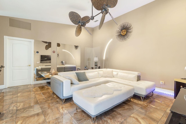 living room with a high ceiling and ceiling fan