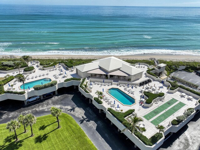 drone / aerial view with a water view and a beach view