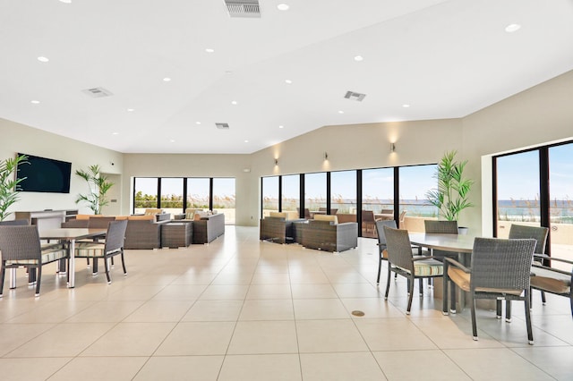 tiled dining room featuring a wealth of natural light and vaulted ceiling