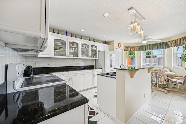 kitchen featuring white appliances, hanging light fixtures, ceiling fan, a textured ceiling, and white cabinetry