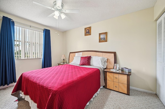 bedroom featuring carpet flooring, ceiling fan, a textured ceiling, and a closet