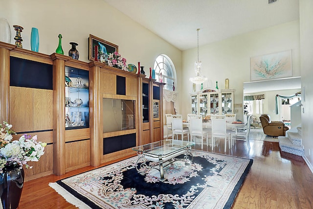 living room featuring a chandelier, hardwood / wood-style floors, and high vaulted ceiling