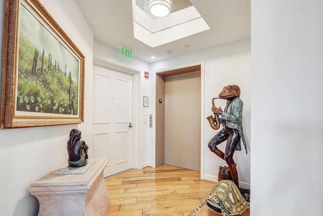 interior space featuring recessed lighting, light wood-style floors, elevator, and a skylight