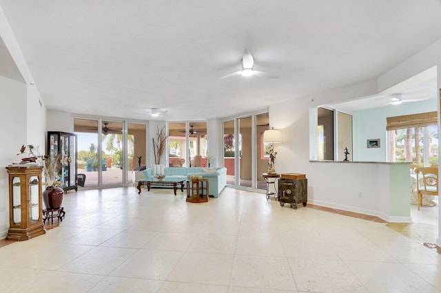 tiled living room featuring plenty of natural light, a ceiling fan, and baseboards
