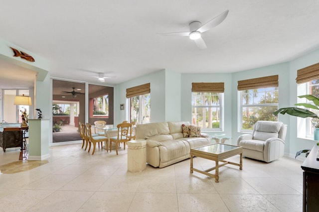 living area featuring a wealth of natural light, ceiling fan, and light tile patterned flooring