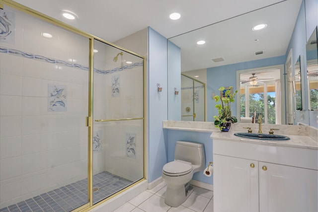 bathroom featuring a shower with door, toilet, ceiling fan, vanity, and tile patterned flooring