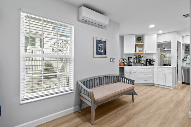 living area featuring light hardwood / wood-style floors and a wall mounted AC