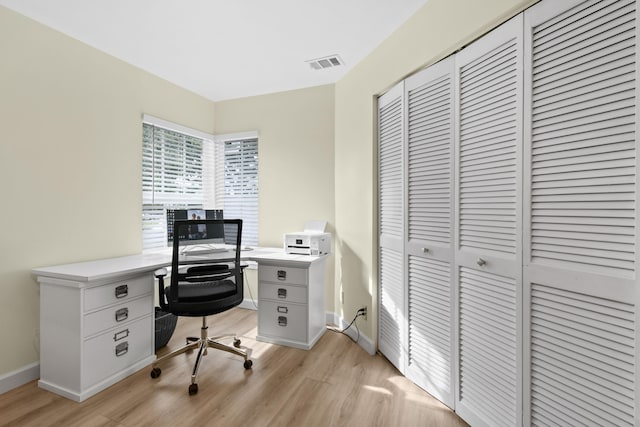 home office with light hardwood / wood-style flooring