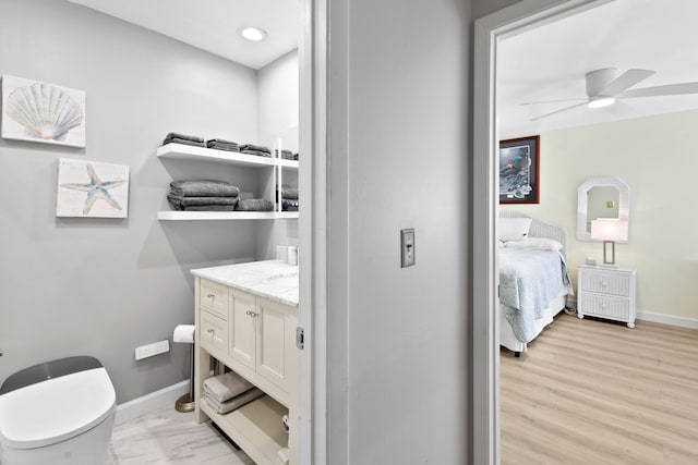 bathroom with ceiling fan, vanity, hardwood / wood-style floors, and toilet